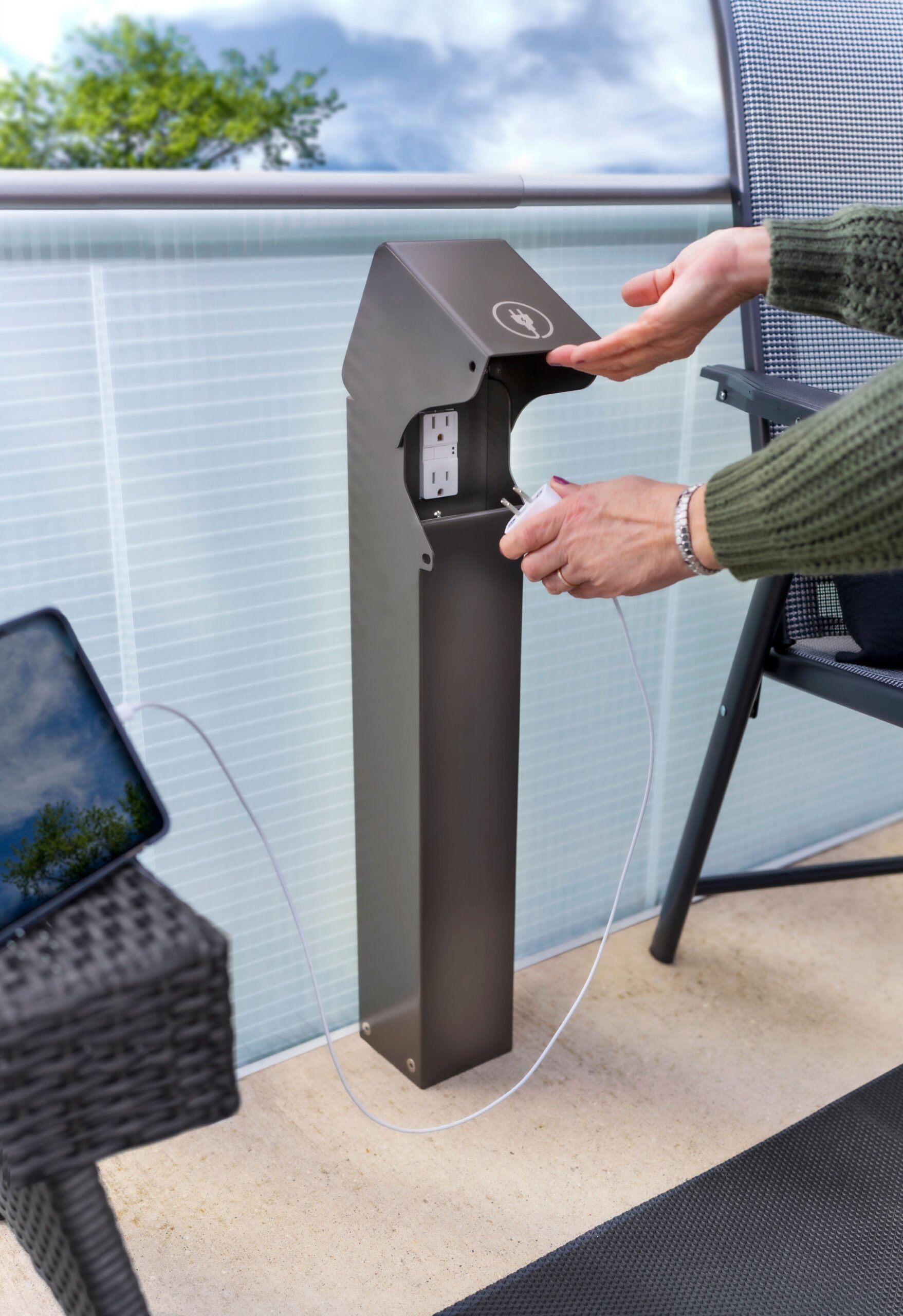 Outdoor power pedestal mounted flush to glass charging an Ipad