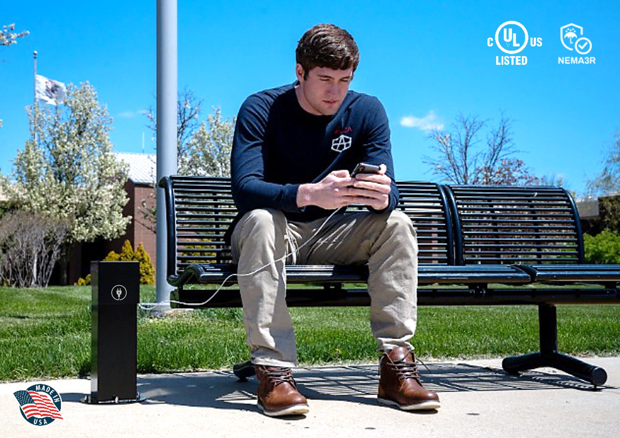 A college student using his phone while plugged into a Pedoc power pedestal